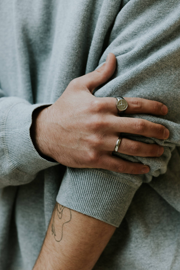 טבעת כסף מפלדת אל-חלד על אצבע גברית, מראה עמיד וסטייל מודגש